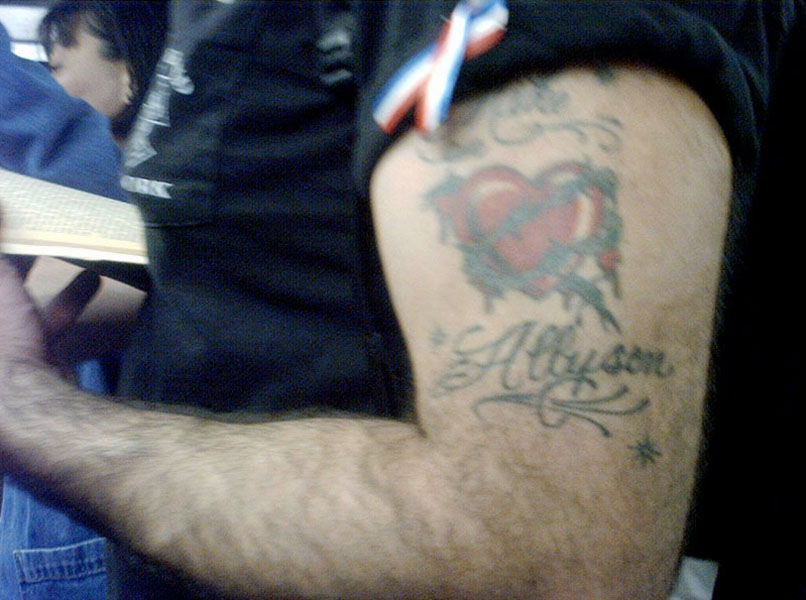 patriotic ribbon-twist and tender tattoo on a muscular arm