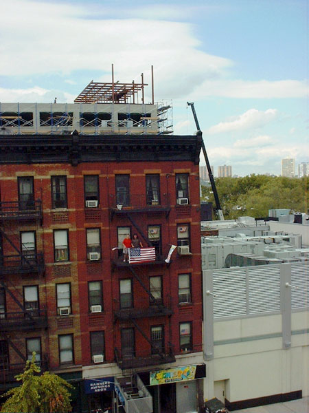 display of flags on tenemant fire escape in Hell's kitchen, New York City