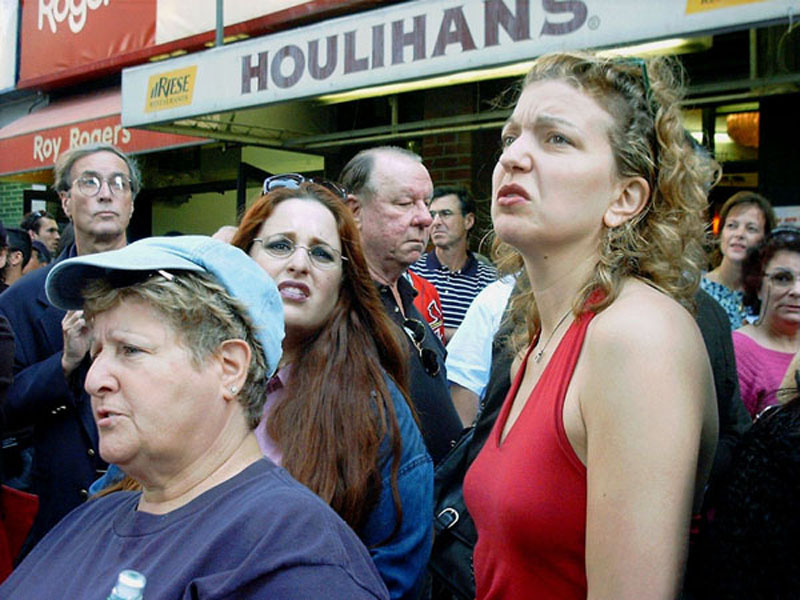 pedestrians react to smoking WTC ruins, seen from lower Broadway